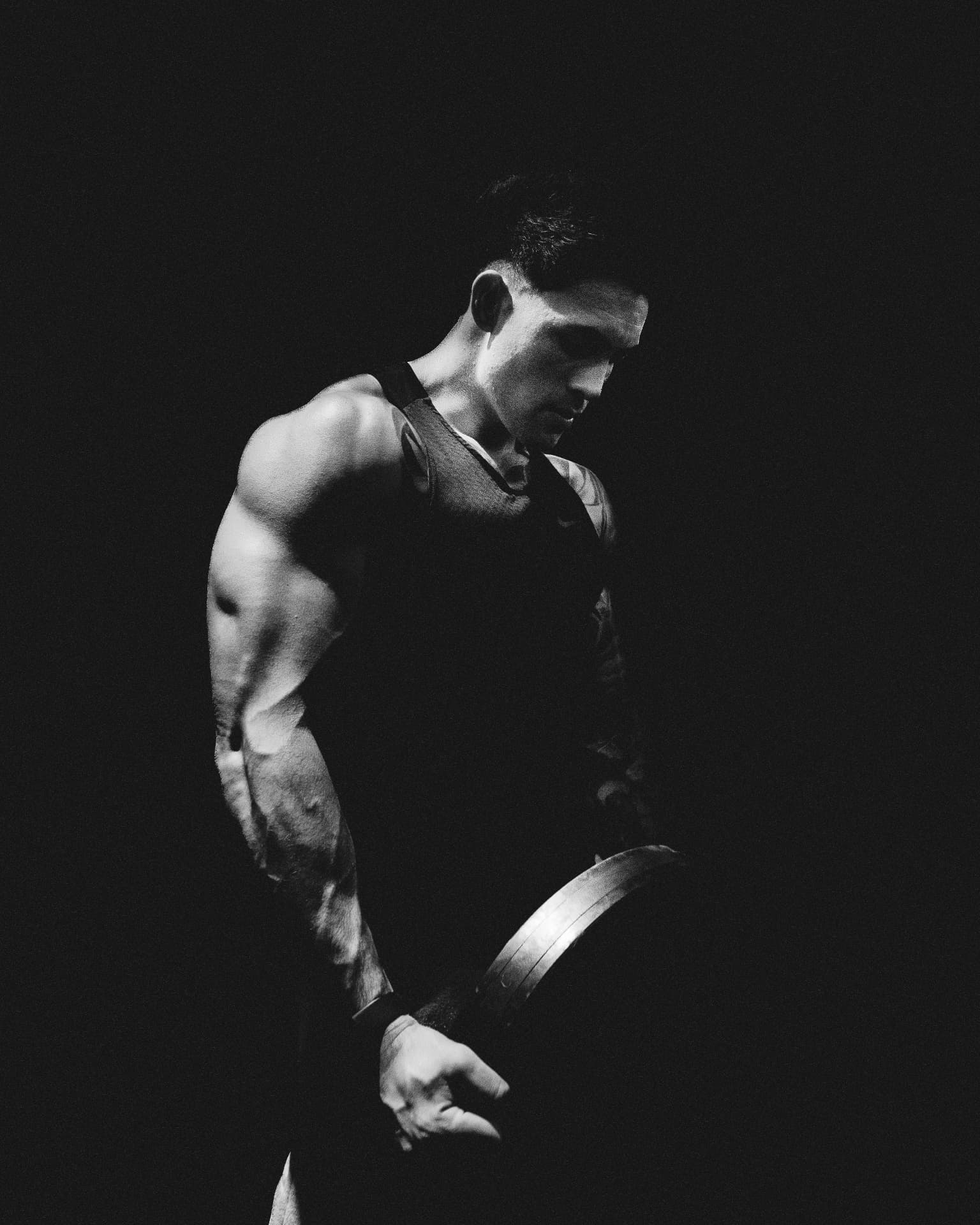Craig O’Meara training with a weight plate, photographed in black and white